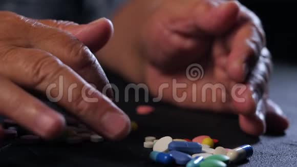 祖母在家里的黑桌上数着五颜六色的药片老年的概念用药治疗特写视频的预览图