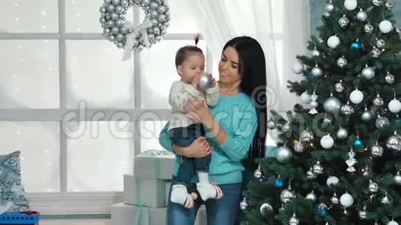 妈妈带着10个月大的女婴在客厅装饰圣诞树视频的预览图