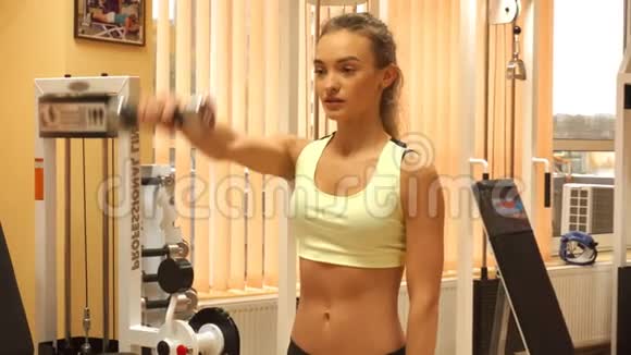 年轻的金发女孩在健身房里闲逛视频的预览图