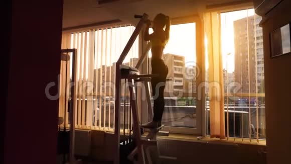 4k日落时分苗条的金发体育女孩在体育馆里辛勤工作视频的预览图