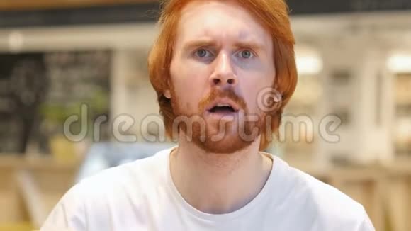 坐在咖啡馆里的红头发胡子男搜索手势视频的预览图