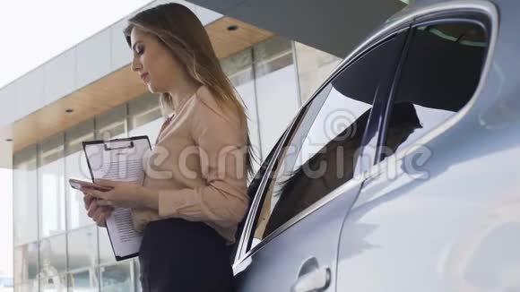 女保险经纪人持有合同在汽车附近等待客户视频的预览图