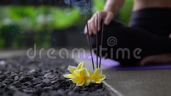 在外面的石楼上用黄色的花把烧香的香棒合上视频的预览图