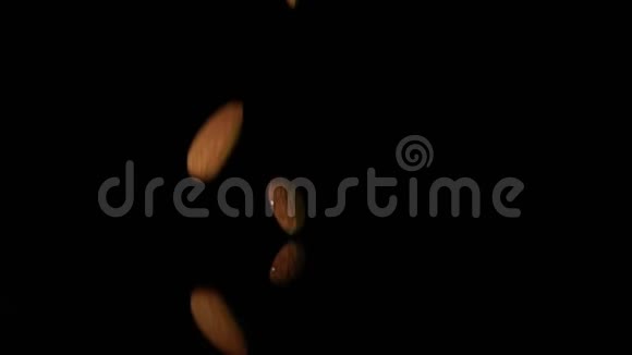 许多新鲜的生杏仁坚果落在黑色背景下健康超级食品视频的预览图