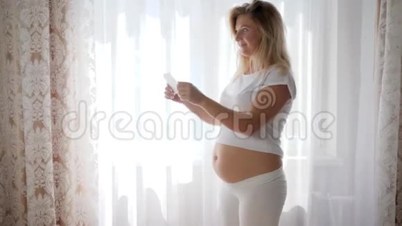 有裸肚子的快乐孕妇欣赏超声波图片婴儿视频的预览图