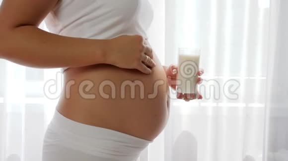 孕妇在室内吃大肚子的牛奶营养奶制品视频的预览图