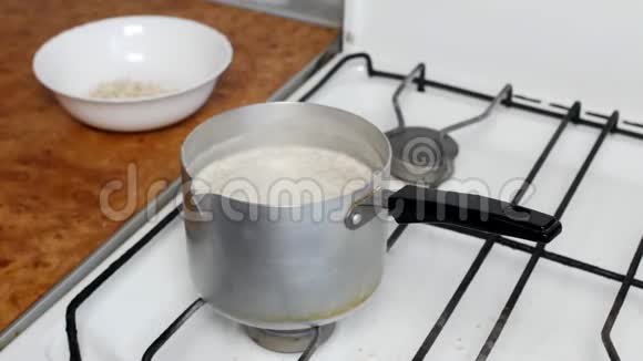 煮燕麦片一个女人用勺子搅拌牛奶然后睡着燕麦片特写麦片早餐视频的预览图