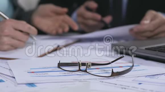 桌子上的眼镜和文件商务会议数据分析视频的预览图