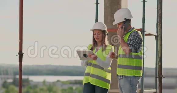 建筑在建筑中有一个女的和一个男的建筑建筑工人工程师沿着它走视频的预览图