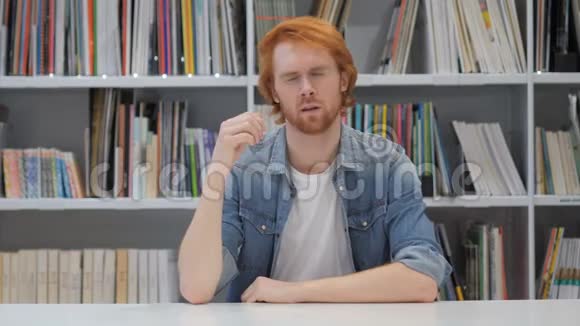 办公室图书馆紧张的红头发男人视频的预览图