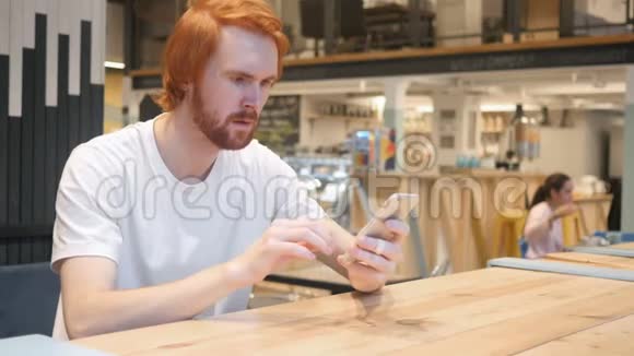 在咖啡馆工作的令人吃惊的令人惊奇的红头胡子男视频的预览图
