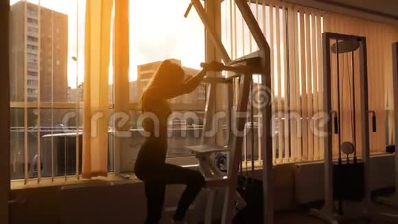 苗条的金发体育女孩在日落时分在4k的健身房练习视频的预览图