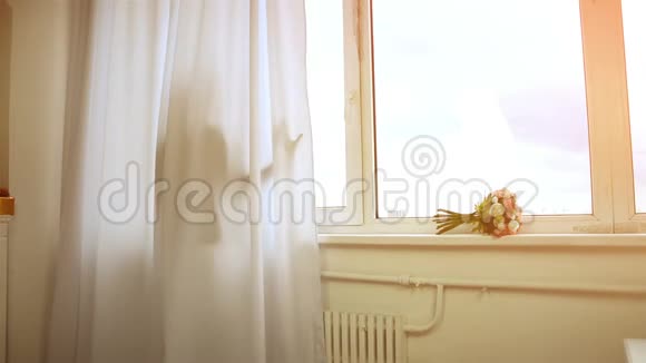 可爱的女孩站在窗帘后面看着窗外的镜头视频的预览图