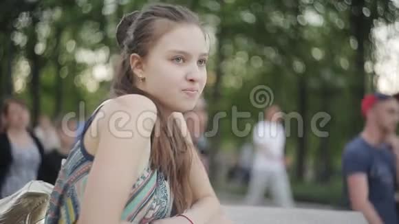 入住城市公园在欢乐人群中孤独的女孩视频的预览图