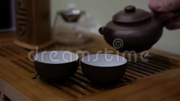 人们把茶壶里的茶倒进碗里中国茶道仪式视频的预览图