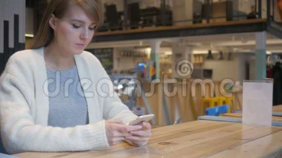 在咖啡馆里使用智能手机的沮丧女人被问题困扰视频的预览图
