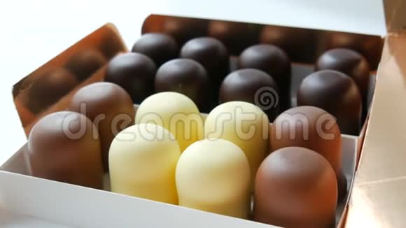 在白色黑色和牛奶巧克力的釉上以糖果的形式提供通风的蛋奶奶甜点一盒巧克力视频的预览图