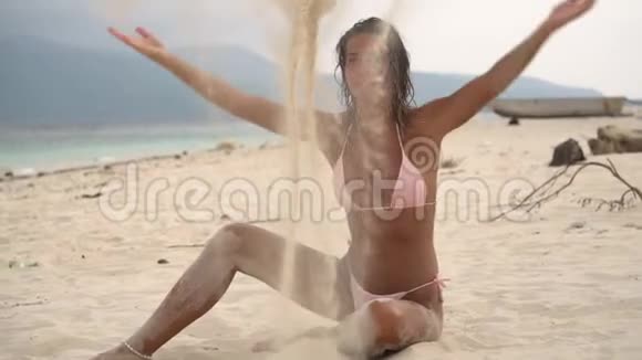 漂亮的年轻女子坐在白沙滩上尽情享受夏天的假期尽情地尽情享受视频的预览图