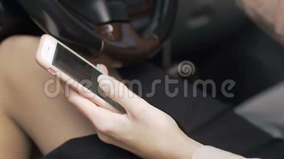 商务女性在社交媒体上滚动手里拿着小玩意坐在车里视频的预览图