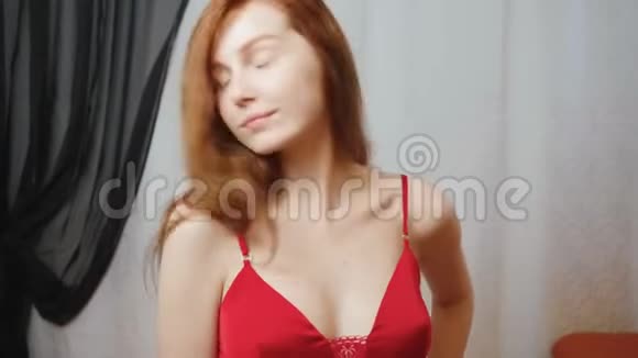 室内穿红色丝绸睡衣的姜女的视频视频的预览图