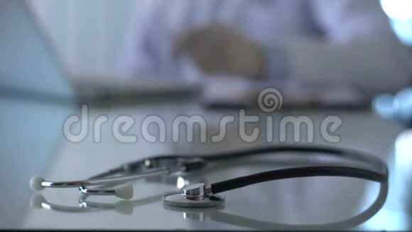 听诊器放在桌子上医生在办公室和诊所用手提电脑工作视频的预览图