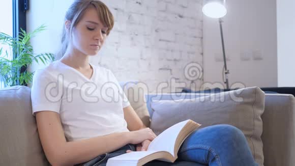 坐在沙发上看书的女人视频的预览图