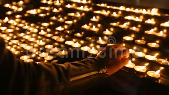 妇女在教堂宗教和信仰精神上点燃蜡烛视频的预览图