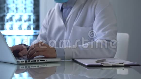 实验室工作人员在笔记本电脑上打字并写下医学观察结果视频的预览图