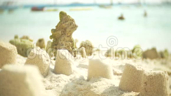 沙滩上的沙滩城堡一个不知名的家庭在公共海滩上建造了一座沙滩城堡4k模糊慢动作视频的预览图