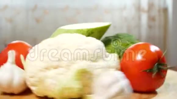 花椰菜西葫芦番茄西兰花和大蒜在木切割板上旋转4k视频的预览图