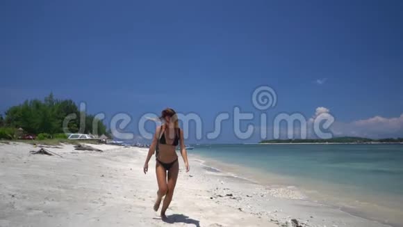 美丽的女人在水晶海的白色沙滩上行走和奔跑视频的预览图