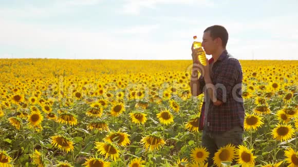 日落时分农夫手里拿着一瓶葵花油葵花籽油能改善皮肤健康促进细胞生长视频的预览图