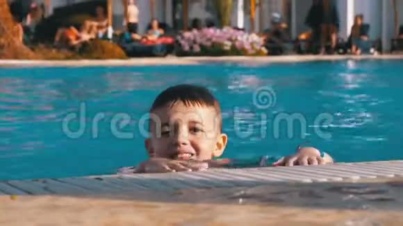 快乐男孩和蓝水在游泳池玩耍视频的预览图