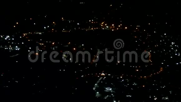 夜晚的城市灯光在飞机机翼下的黑暗中闪烁视频的预览图
