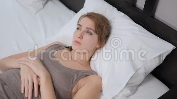 躺在床上的女人感到不舒服不舒服视频的预览图