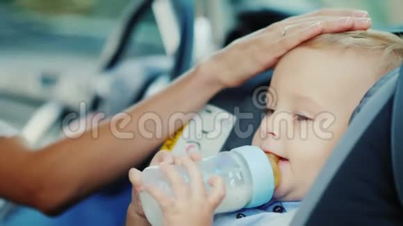 婴儿1岁时喝一瓶牛奶坐在儿童座椅上视频的预览图