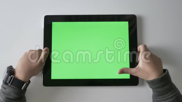 孩子们手在平板电脑上滑动绿色屏幕色度概念顶部拍摄60fps视频的预览图