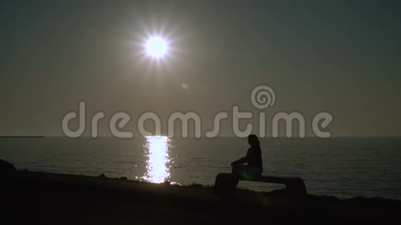 日落时一个女孩正沿着海滨散步视频的预览图