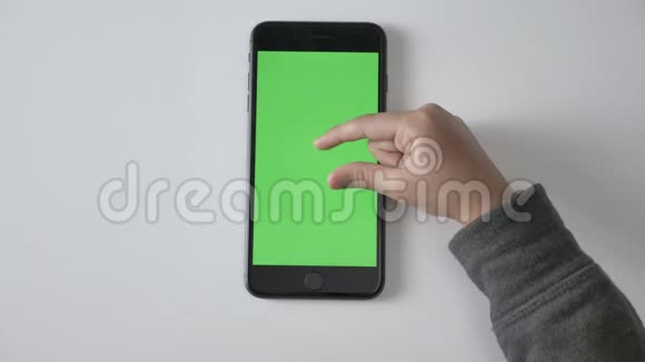 孩子们手在智能手机上做捏来缩放手势绿色屏幕色度概念顶拍60fps视频的预览图