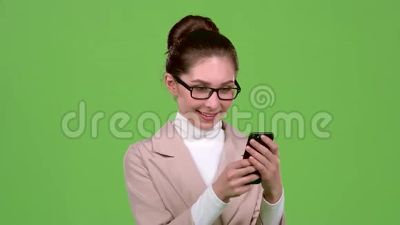 商务女士看她的智能手机上的照片绿色屏幕视频的预览图