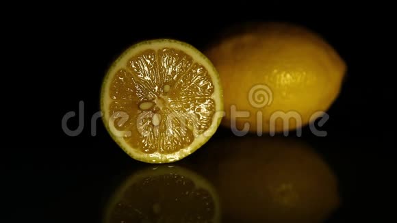 一片柠檬和一整片多汁的柠檬放在一张深色的镜子桌上视频的预览图