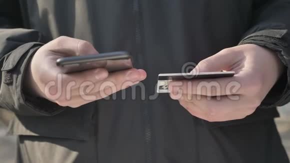 男人手里拿着一部黑色的大智能手机和信用卡网上银行购物网上商店60fps视频的预览图