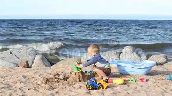 一个小男孩正在海边玩沙子和梨视频的预览图