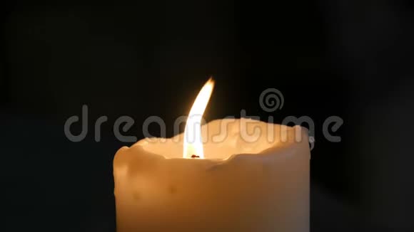在德国的一个古老的中世纪教堂里白色的大蜡烛燃烧着站在黑色的背景上视频的预览图