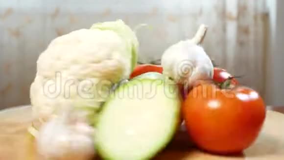 花椰菜西葫芦番茄和大蒜在木切割板上旋转4k视频的预览图