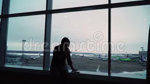 在机场候机楼等待航班的女人视频的预览图