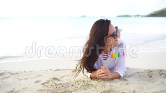 在热带海滨玩得很开心的年轻美女快乐的女孩躺在白沙热带海滩上视频的预览图
