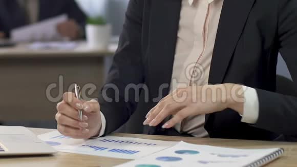 女经理比较两张图表并在办公室企业做笔记视频的预览图