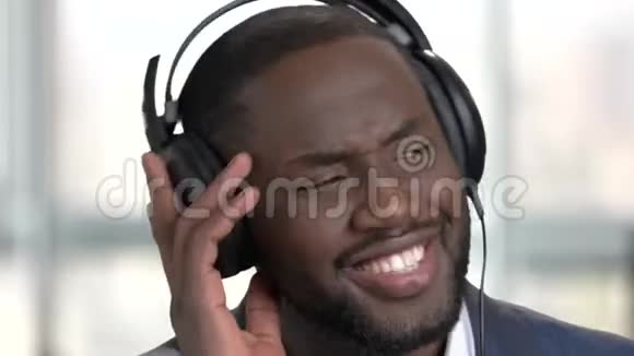 穿西装的黑人带着耳机听音乐视频的预览图