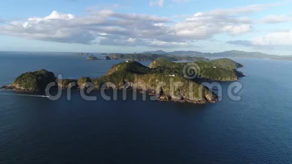 令人惊叹的4k无人机在深蓝色平静的海水海景中的大森林山热带岛屿上的景色视频的预览图